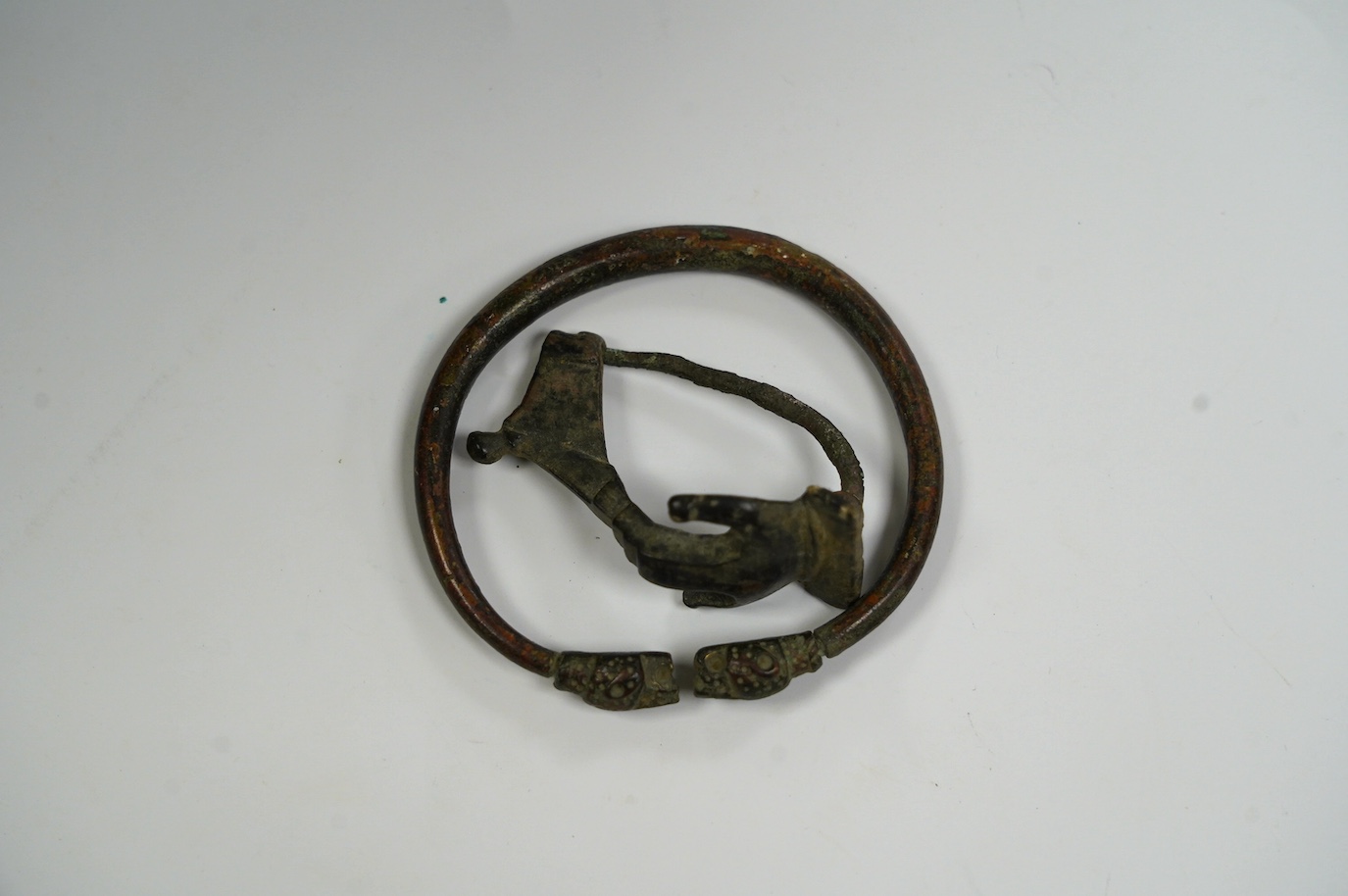 A bronze bracelet, probably Luristan and a Roman bronze fibula brooch (2). Condition - fair